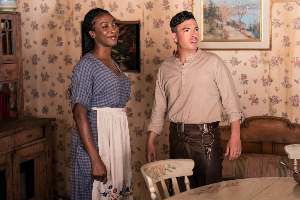 Scraps stands next to his wife in a country-style, 1950s-esque kitchen in Miracle Workers: End Times Season 4 Episode 7, "Roland Proudheart."