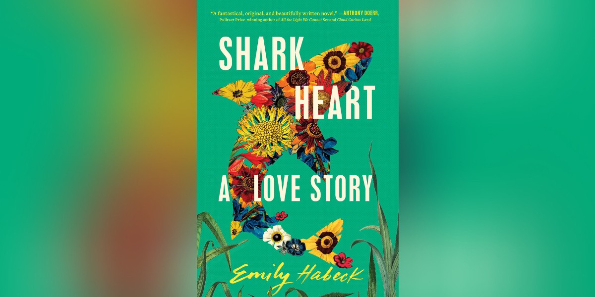 The cover of Shark Heart has a shark made of flowers on a green background with grass below.