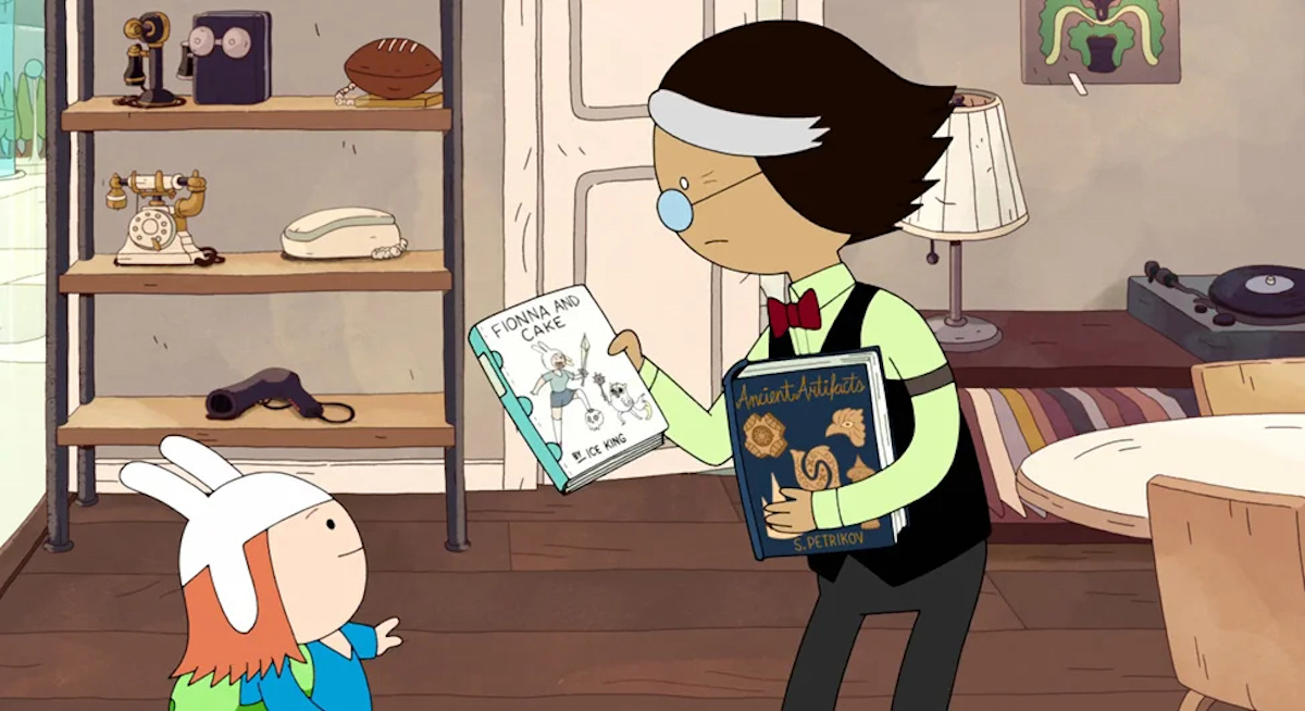 Simon Petrikov (Tom Kenny) holds two books he wrote in his 20th century apartment replica.