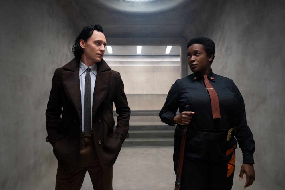 Loki and Hunter B-15 walk side-by-side down a hallway while talking in Loki Season 2 Episode 2, "Breaking Brad."