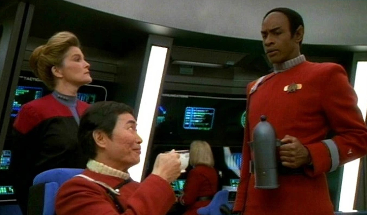 Janeway (Kate Mulgrew) looks on as Tuvok (Tim Russ) pours tea for Sulu (George Takei).