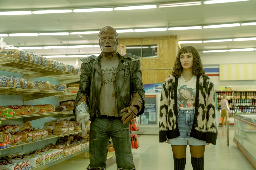 Cliff and Jane stand in the aisle of a grocery store while looking confused in Doom Patrol Season 4 Episode 7, "Orqwith Patrol."