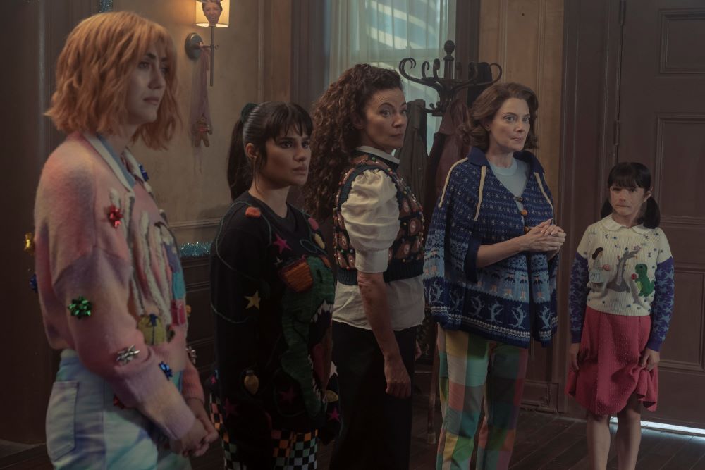 Casey, Jane, Laura, Rita and Dorothy wear holiday-themed ugly sweaters while standing in a house and looking at something off-screen in Doom Patrol Season 4 Episode 9, "Immortimas Patrol."