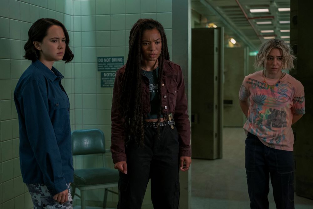 Jordan (in their female form), Marie and Emma stand in the basement of a building that looks like a lab/prison in Gen V Season 1 Episode 8, "Guardians of Godolkin."