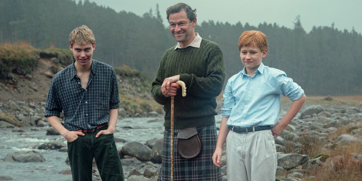 Young Prince William and young Prince Harry pose with a middle-aged Prince Charles for a photo with the Scottish Highlands as a backdrop in Season 6 of Netflix's The Crown.