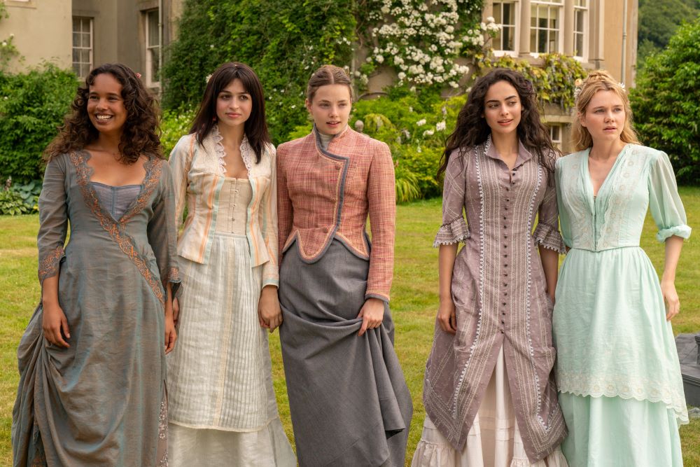 Conchita Marable, Mabel Elmsworth, Nan St. George, Lizzy Elmsworth and Jinny St. George wear Victorian gowns of varying colors while standing outside in front of a lavish home in The Buccaneers Season 1 Episode 2, "Women or Wives."
