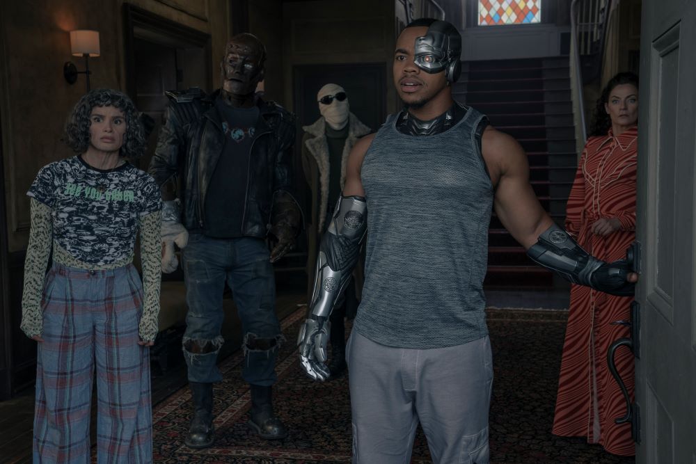 Jane, Cliff, Larry, Vic and Laura stand in the doorway of Doom Manor while looking confused in Doom Patrol Season 4 Episode 12, "Done Patrol."