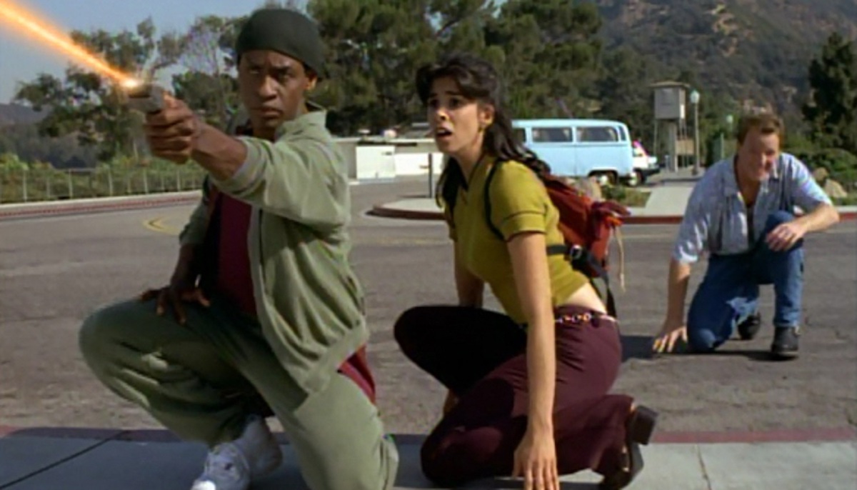 Tuvok (Tim Russ) fires a phaser in a parking lot while Rain Robinson (Sarah Silverman) and Tom Paris (Robert Duncan McNeill) look on.