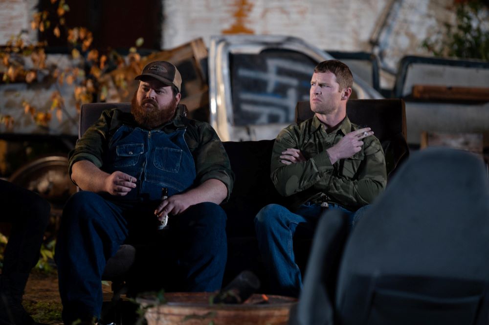 Squirrely Dan and Wayne sit on chairs in a dump outside at night while smoking cigarettes in Letterkenny Season 12 Episode 5, "Stuck."
