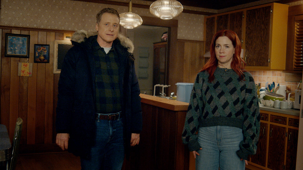 Harry and D'Arcy stand in the kitchen of a house while looking confused in Resident Alien Season 3 Episode 1, "Lone Wolf."