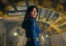 Lucy wears her blue and yellow vault dweller suit while standing inside Vault 33. She looks over her shoulder on Fallout Season 1 Episode 1, "The End."