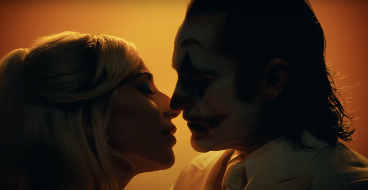 a close up of harley quinn kissing the joker in joker: folie a deux