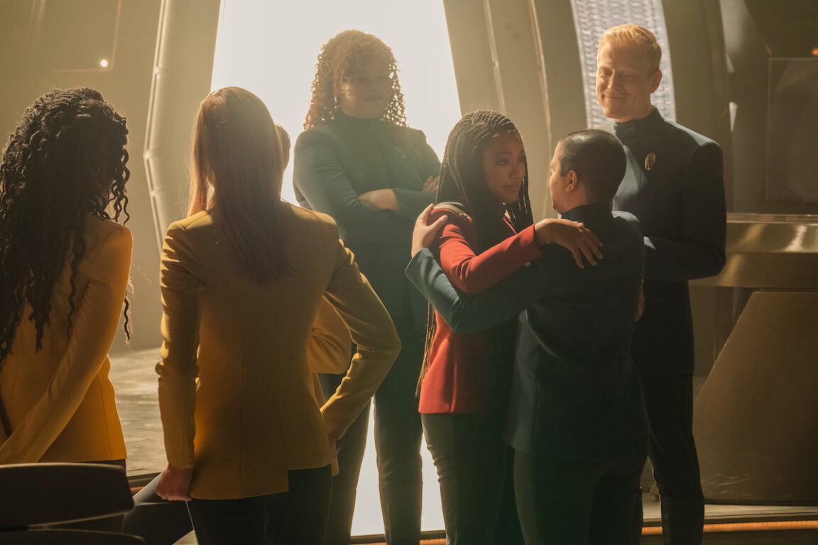 The Discovery crew embrace on the bridge.