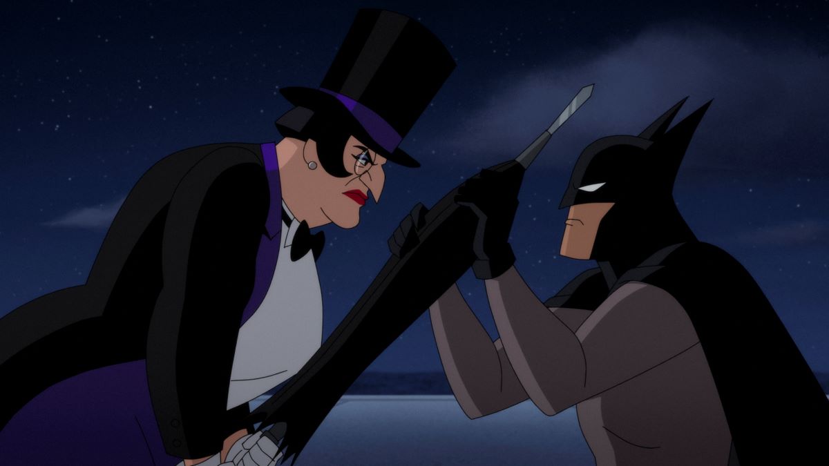The Penguin, dressed in a top hat with a purple band and a tuxedo, attacks Batman with her umbrella. They face off against each other in profile to the camera. Batman is struggling to keep the umbrella from striking him, gripping it with both hands. He wears a black cowl and mark with a grey skin suit.