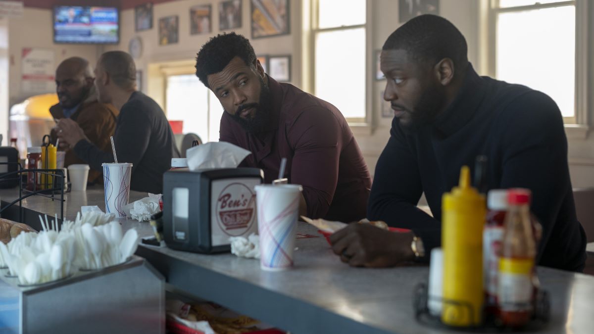 Sampson sits at a diner counter looking to his left at Cross. Cross Season 1 Episode 8 "You Had Me at Motherf*cker"