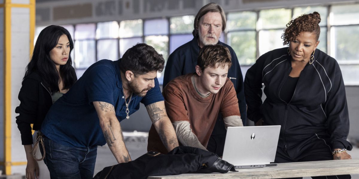 Mel, Harry, Fisk and Robyn surrounding a young man working on his computer on "The Equalizer."