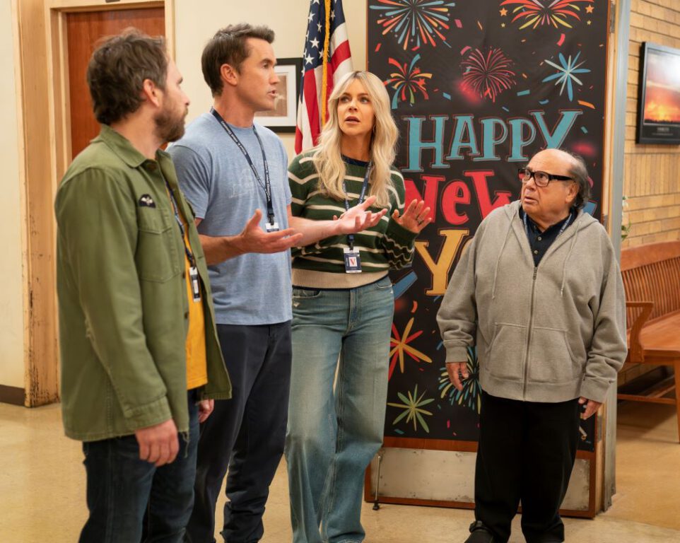 Charlie, Mac, Dee, and Frank from It's Always Sunny in Philadelphia stand in the hallway of Abbott Elementary while talking to someone off-screen.