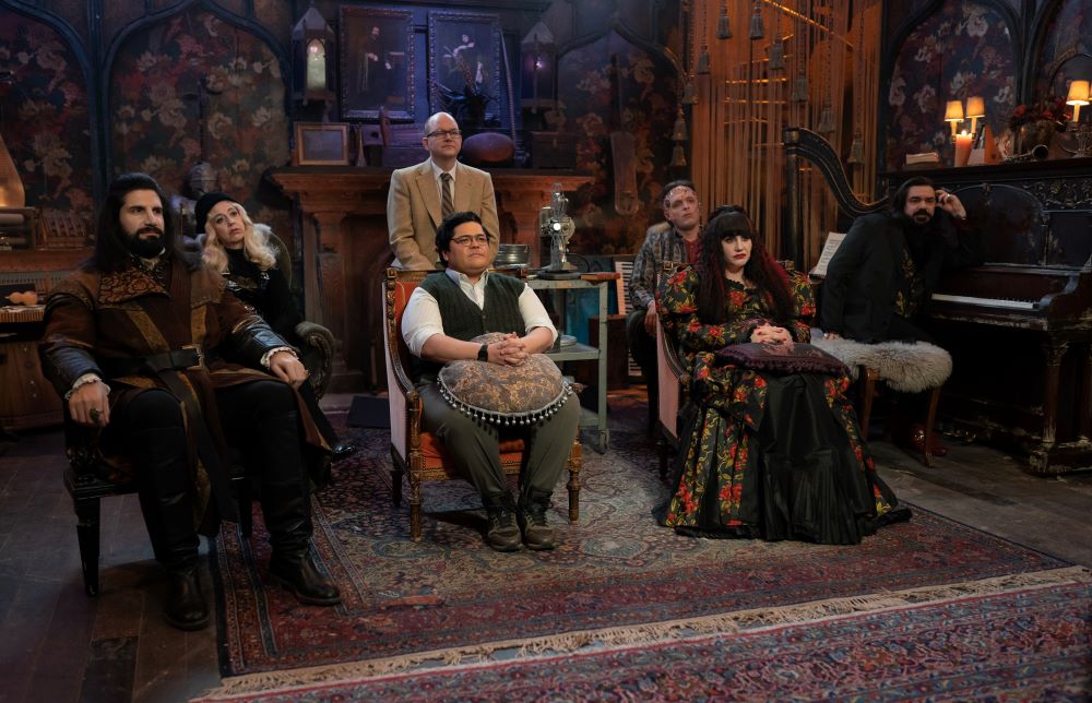 The vampires sit in a brightly lit sitting room while watching something on a projector on What We Do in the Shadows Season 6 Episode 11, "The Finale."