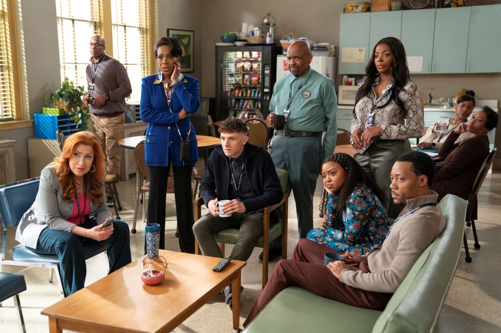 Melissa, Barbara, Jacob, Mr. Johnson, Ava, Janine and Gregory sit in the teachers' breakroom while watching TV on Abbott Elementary Season 4 Episode 12, "Girard Creek."
