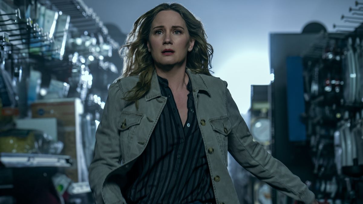 Maryanne rushes down the aisle of a hardware store. She wears a light trench over a dark button-front blouse on The Bondsman Season 1 Episode 4, "Erdos."