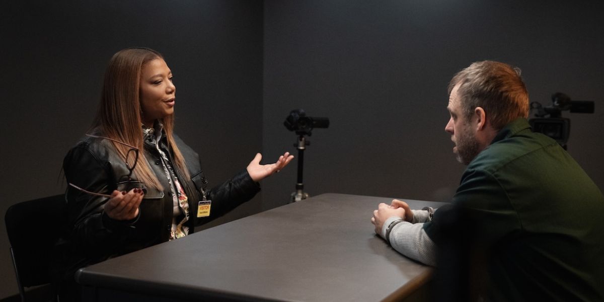 Robyn sitting across from a prisoner in the interrogation room on "The Equalizer."