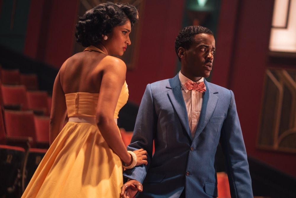 Belinda Chandra and the Doctor wear 1950s garb while standing in the auditorium of a theater on Doctor Who Season 2 Episode 2, "Lux."