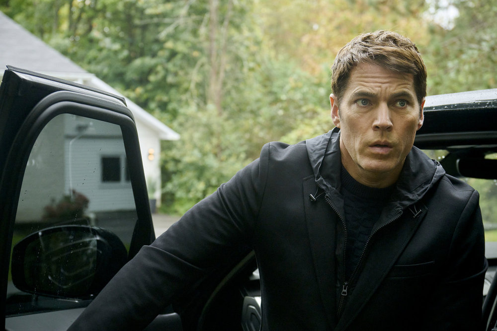 Luke emerges from his vehicle while outside in the woods during the day on SurrealEstate Season 3 Episode 1, "Buckaroo."