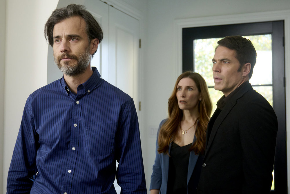 Mitch, Susan and Luke stand in the foyer of a brightly lit home with white walls on SurrealEstate Season 3 Episode 2, "Night Terrors."