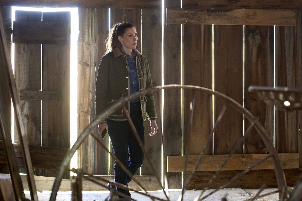 Susan walks through a dimly lit barn on SurrealEstate Season 3 Episode 3, "Death Does a Refi."