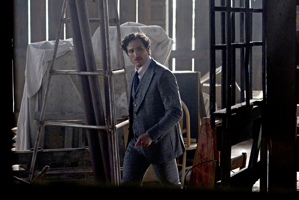 Keith walks through a dimly lit barn on SurrealEstate Season 3 Episode 3, "Death Does a Refi."