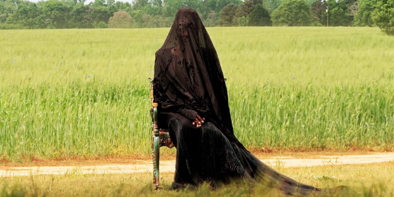The Woman in the Yard (Okwui Okpokwasili) sits on a chair in the yard in The Woman in the Yard