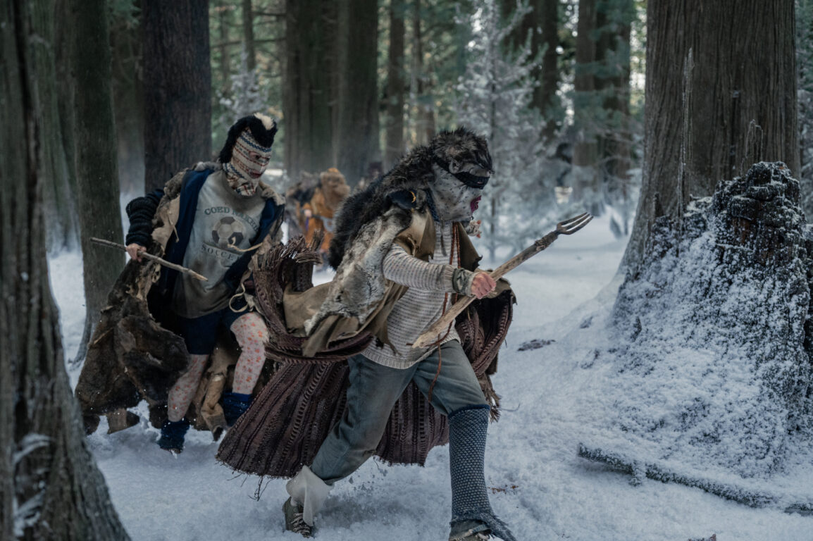 The teens wear furs and mismatched clothing while brandishing weapons and running through the snowy woods on Yellowjackets Season 3 Episode 10, "Full Circle."