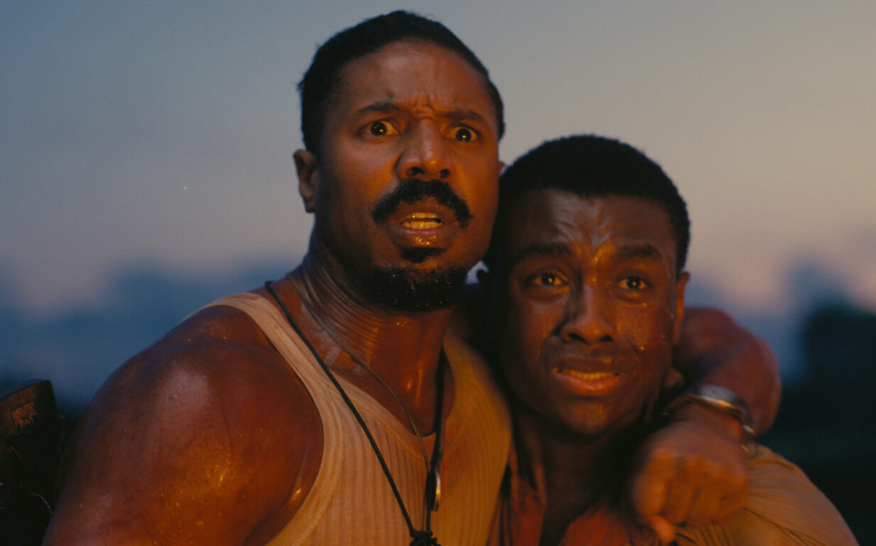 Michael B Jordan holds tightly to Miles Caton as they look on in horror in the movie Sinners.