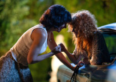 Greta and Charlie link pinky fingers while touching foreheads outside at night on Poker Face Season 2 Episode 2, "Last Looks."