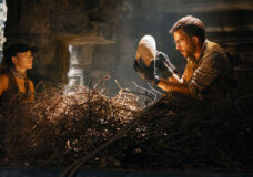 Zora Bennett and Dr. Henry Loomis stand around a pterodactyl nest. Loomis is holding an egg in the film Jurassic World Rebirth.