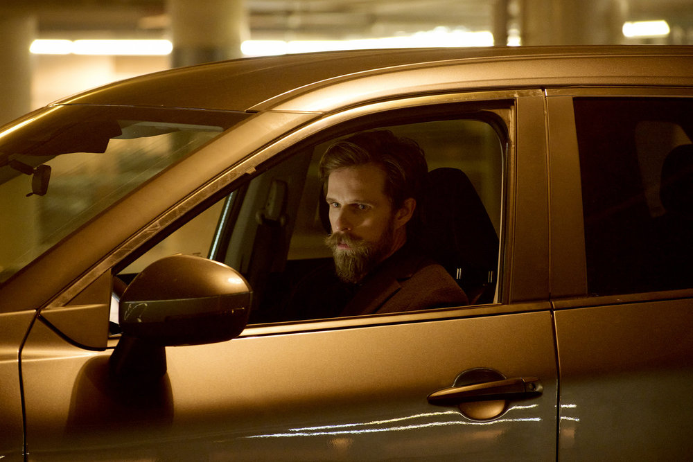 Tyler sits in his vehicle in a parking garage at night while looking menacing on SurrealEstate Season 3 Episode 7, "A Slice of Afterlife."