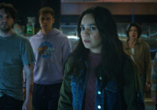 Stefani Reyes and her pals stand in a dimly lit room while looking shocked in the horror film Final Destination: Bloodlines.