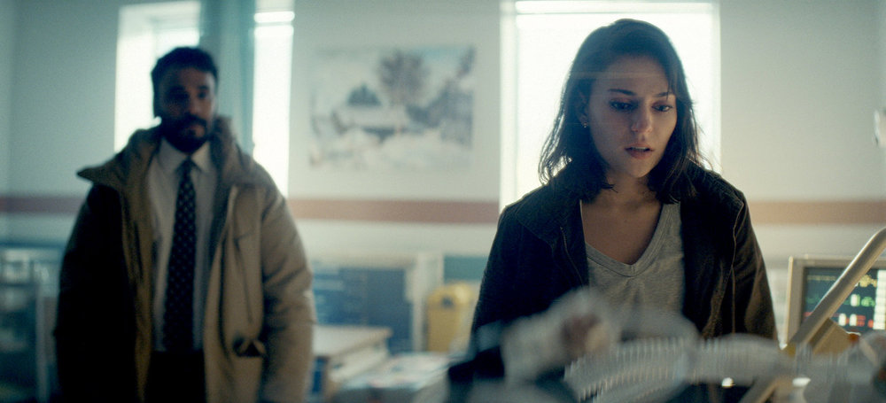Em stands by Dana's hospital bed in her room while Ibrahim stands some distance behind them on Revival Season 1 Episode 5, "Triage."