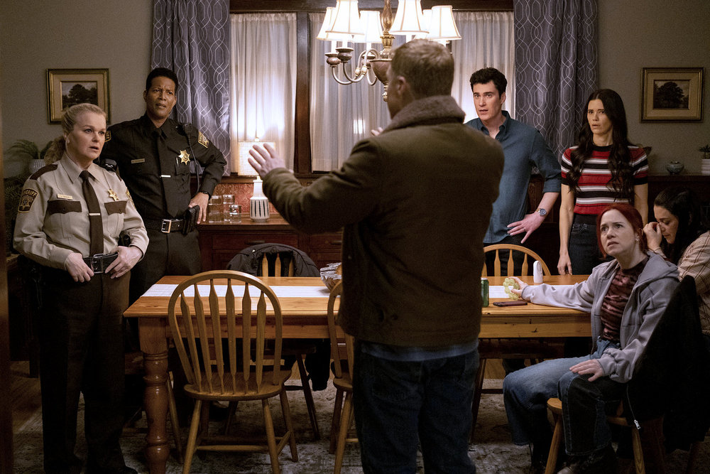 Harry chats with our main characters as they stand around a dinner table on Resident Alien Season 4 Episode 10, "The End Is Here."